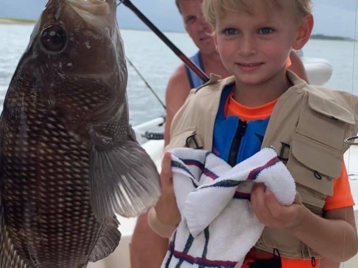 a little girl holding a fish
