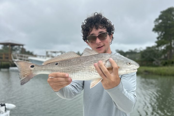 a man holding a fish in the water