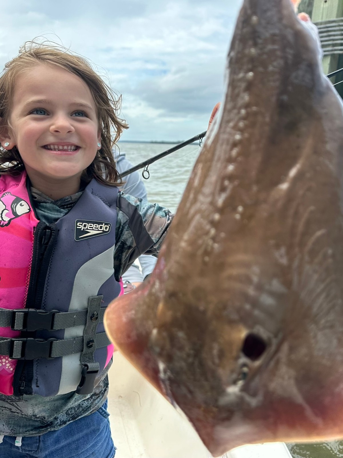 a little girl holding a fish
